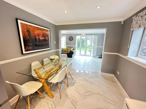 a dining room with a glass table and chairs at Modern 3 bed House with two bathrooms! Free parking! in Bar Hill