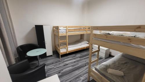 a room with bunk beds and a desk and a table at Small apartment for groups in city centre in Prague