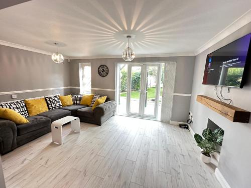 a living room with a couch and a tv at Modern 3 bed House with two bathrooms! Free parking! in Bar Hill