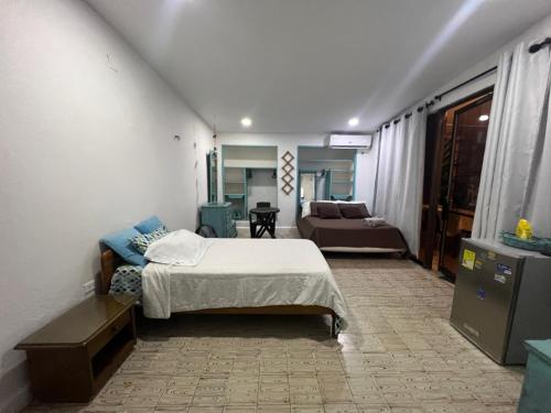 ein Schlafzimmer mit einem Bett und einem Sofa in einem Zimmer in der Unterkunft Apartaestudios norte de barranquilla in Barranquilla