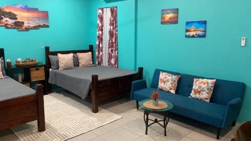Canouan的住宿－Lydia`s View，一间卧室设有一张床和蓝色的墙壁