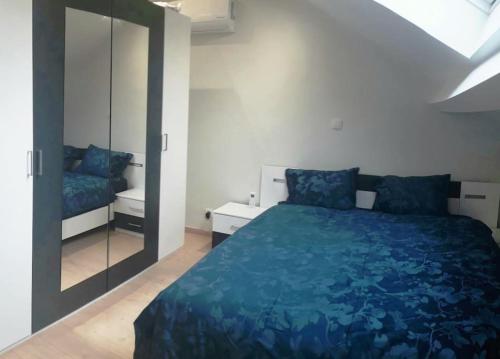 - une chambre avec un lit bleu et un miroir dans l'établissement SweetPlace Forever in Charleroi (Appart 4), à Charleroi
