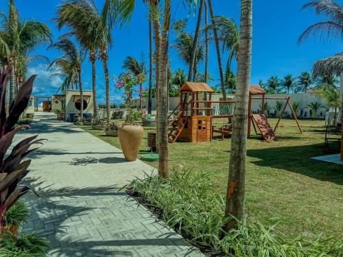 a sidewalk with a playground and palm trees at Isla Beach Hotel in Pecém