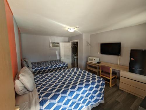 Habitación de hotel con 2 camas y TV de pantalla plana. en El Rey Motel, en Globe
