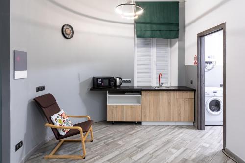 a living room with a chair and a kitchen at Cozy apartments center in Lviv