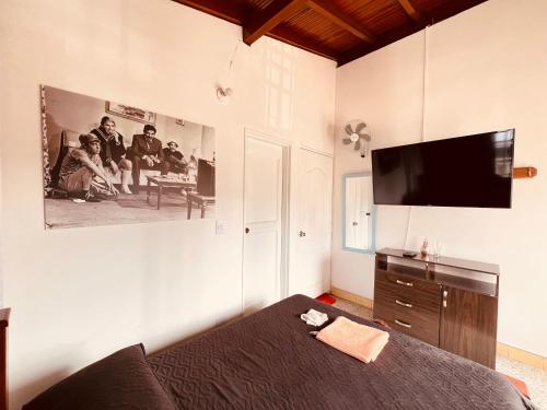 um quarto com uma cama e uma televisão de ecrã plano em Hospedaje La Nave em Bello