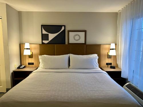 a large bed in a hotel room with two lamps at Staybridge Suites Milwaukee West-Oconomowoc by IHG in Oconomowoc