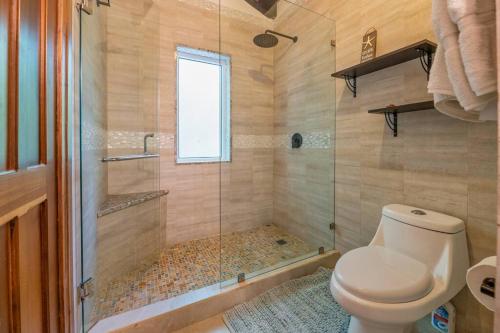 a bathroom with a toilet and a glass shower at Roatan Seaside Rentals in West Bay