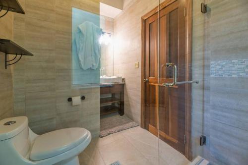 a bathroom with a toilet and a glass shower at Roatan Seaside Rentals in West Bay