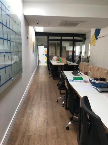 un bureau avec rangées de bureaux et de chaises dans une pièce dans l'établissement Coworking Coletivo Zen, à São Paulo