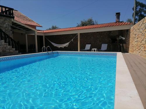 a swimming pool in front of a house at Private Pool & House - Serenity Villa in Ancião