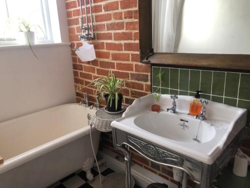 a bathroom with a white sink and a bath tub and a sink at Lovely room in period townhouse in Winchester