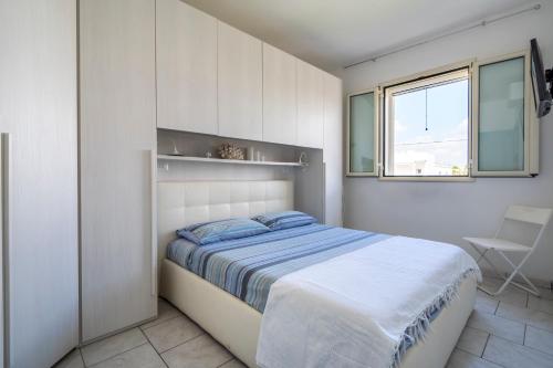 um quarto branco com uma cama e uma janela em Casa Luna 100 mt dalla spiaggia em Maruggio