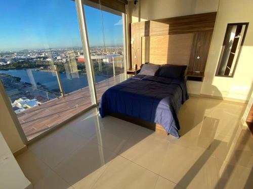 a bedroom with a bed and a balcony with a view at Departamento con vista al mar in Mazatlán