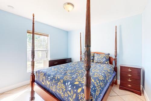1 dormitorio con 1 cama con edredón azul en Pastel Palms, en Lehigh Acres