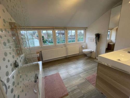 a large bathroom with a toilet and a sink at Villa James in Koksijde