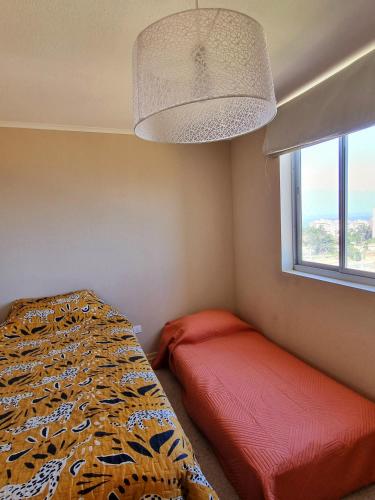 Schlafzimmer mit einem Bett und einem Fenster in der Unterkunft Departamento Laguna Vista in Algarrobo