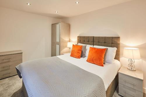 een slaapkamer met een groot bed met oranje kussens bij The Hideaway - Apartment 8 in Sunderland