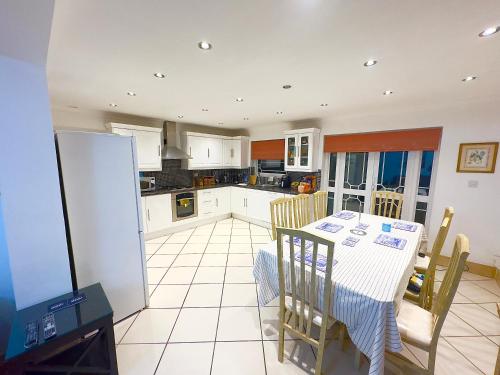 a kitchen with a table and chairs and a refrigerator at Lime Tree House in Heston