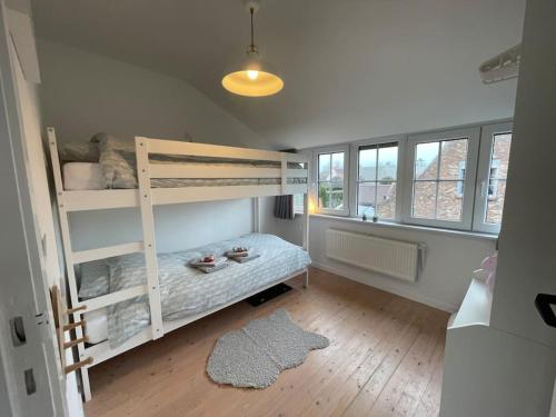 a bedroom with two bunk beds and a wooden floor at Villa James in Koksijde