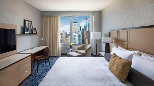 a hotel room with a bed and a view of a city at InterContinental New York Times Square by IHG in New York