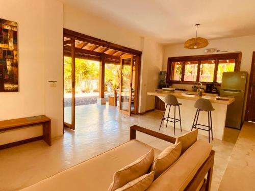 a living room with a couch and a kitchen at Villas Argan - Paradise Gateway in Santa Teresa Beach