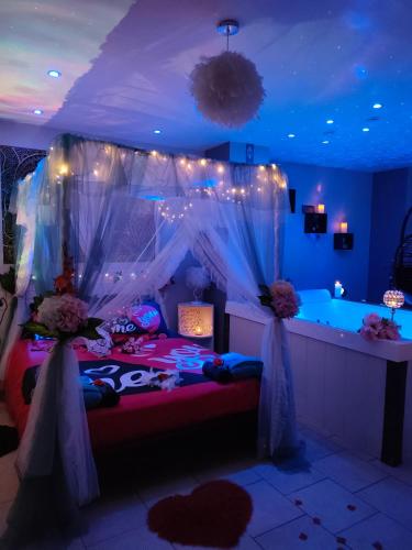 a bedroom with a bed with a canopy and lights at Loft avec Baignoire SPA LÉcrin Romantique in Ochancourt