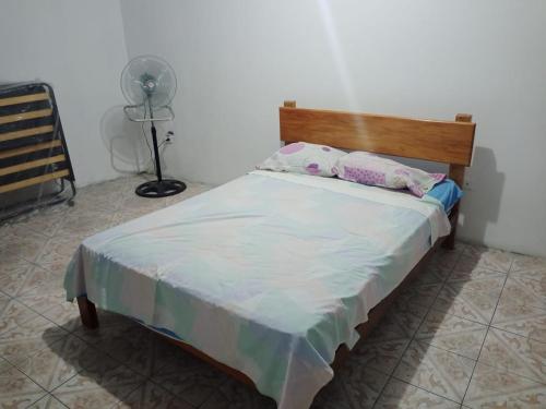 1 cama con 2 almohadas y ventilador en una habitación en FLAVIO REZABALA, en Manta