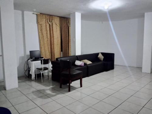 sala de estar con sofá negro y mesa en FLAVIO REZABALA, en Manta