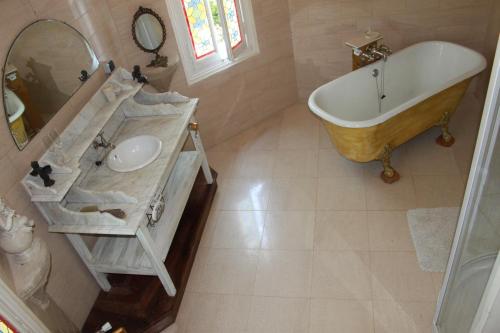 une salle de bain avec un lavabo et une baignoire dans l'établissement Corail, à Queyssac