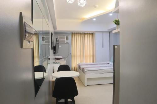 ein Krankenhauszimmer mit einem Bett, einem Tisch und Stühlen in der Unterkunft City Haven at Avida Riala Towers in Cebu City