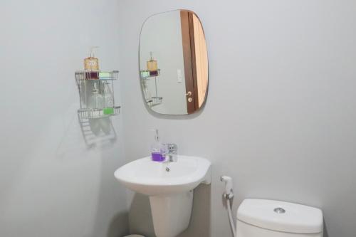 a white bathroom with a sink and a mirror at City Haven at Avida Riala Towers in Cebu City