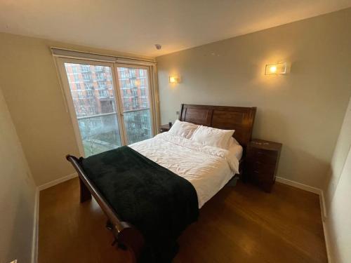 a bedroom with a bed and a large window at 1 Bed Modern Flat in London