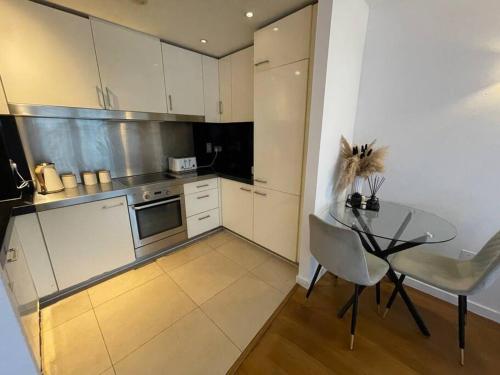 a kitchen with a glass table and a table and chairs at 1 Bed Modern Flat in London