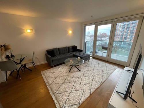 a living room with a couch and a table at 1 Bed Modern Flat in London