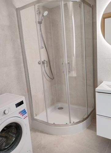 a shower in a bathroom with a washing machine at Apartament 8 Piętro self check-in, parking in Rzeszów