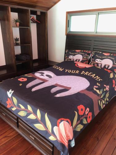 a bedroom with a bed with a flowery comforter at Sloth Premium Riverfront Jungle Villa with Jacuzzi and Pool in Uvita