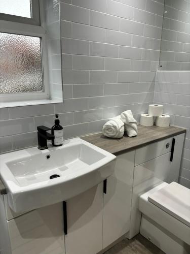 Baño blanco con lavabo y aseo en Cozy 3 Bed Home in Halifax with Secure Parking - Long & short stays welcome!, en Halifax