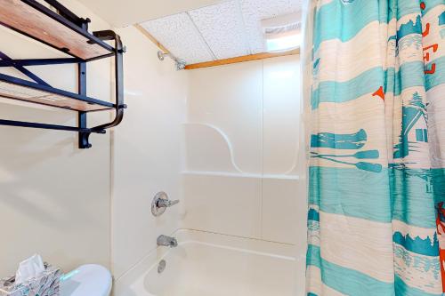 a bathroom with a shower curtain and a toilet at Alpine Horn Lodge at Big Powderhorn Mountain - Unit C in Ironwood