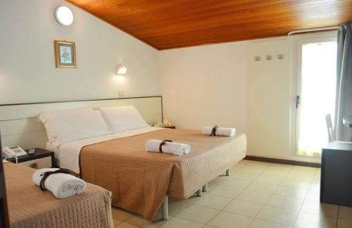 1 dormitorio con 2 camas y toallas. en Hotel Europa Milano Marittima en Milano Marittima