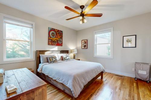 a bedroom with a bed and a ceiling fan at Artsy City Landing in Asheville