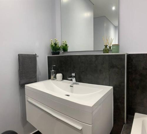 a bathroom with a white sink and a mirror at Modern Exec 2Bed Apartment at Infinite in Johannesburg