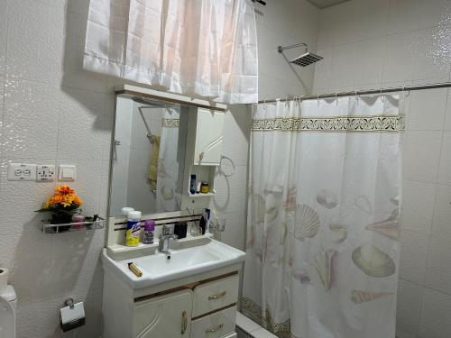 a bathroom with a sink and a shower curtain at Marrets International Villa in Accra