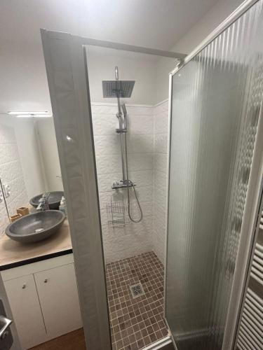 une douche avec une porte vitrée dans une salle de bain dans l'établissement ASMAR, à Toulouse