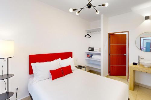 a bedroom with a white bed and a red headboard at Cadetes 47 #203 in Mexico City