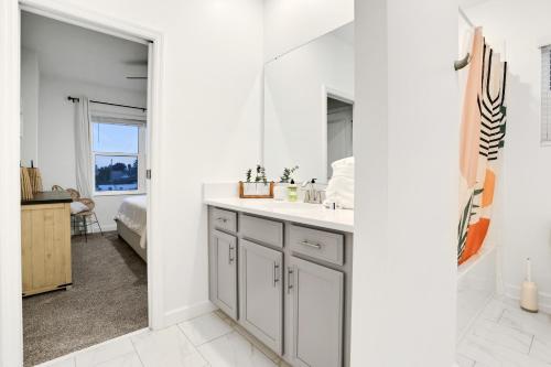 a white bathroom with a sink and a mirror at The Pearly Palm in Melbourne Beach