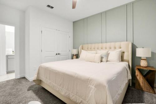a bedroom with a large white bed with white pillows at The Pearly Palm in Melbourne Beach