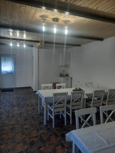 a dining room with white tables and chairs and lights at Cabana Andy in Rausor