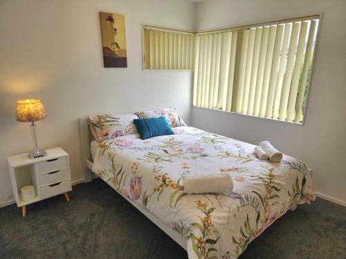Schlafzimmer mit einem Bett und einem Fenster in der Unterkunft Incredible Waitakere View in Auckland