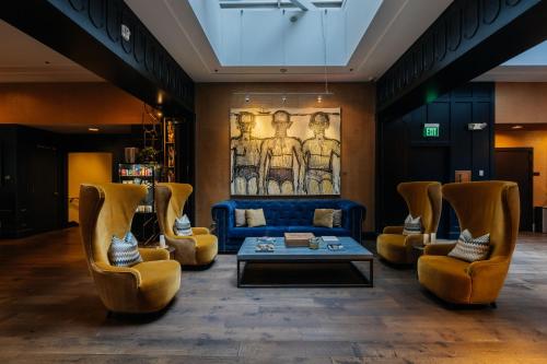 a living room with a blue couch and chairs at Hotel Lucia in Portland